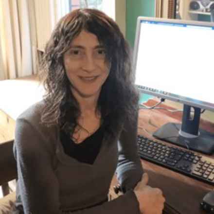 Noemi Lois sitting at desk smiling at camera