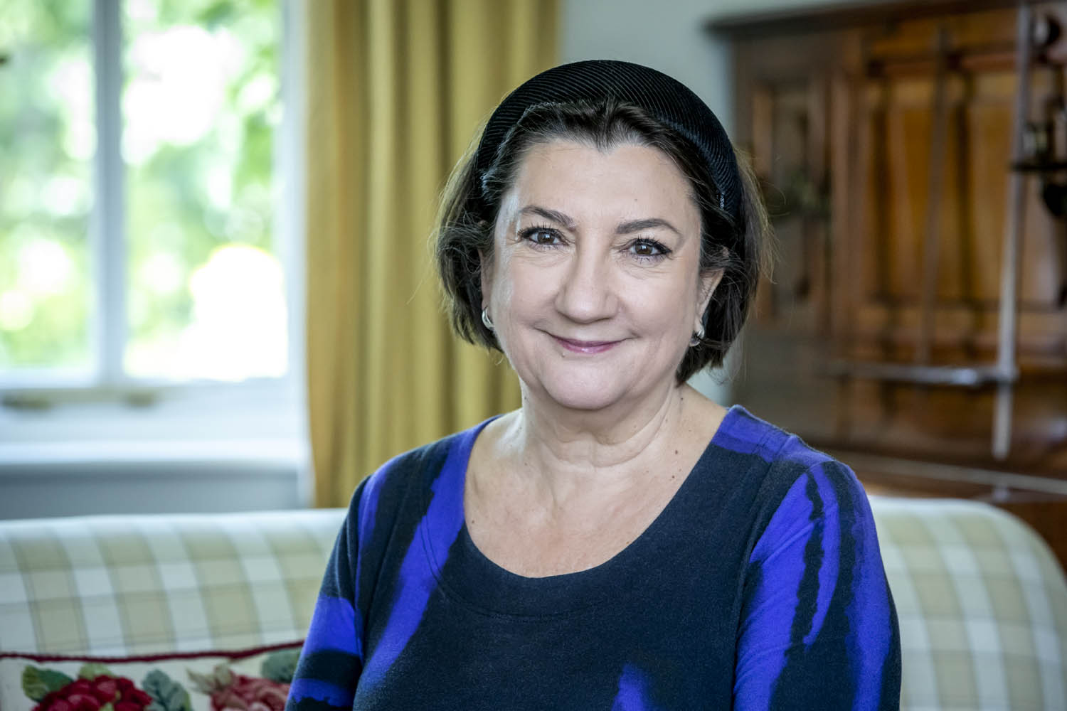 Image of Cathy a white woman in her 60s with short dark hair wearing blue and black and smiling with a closed mouth, looking at the camera 
