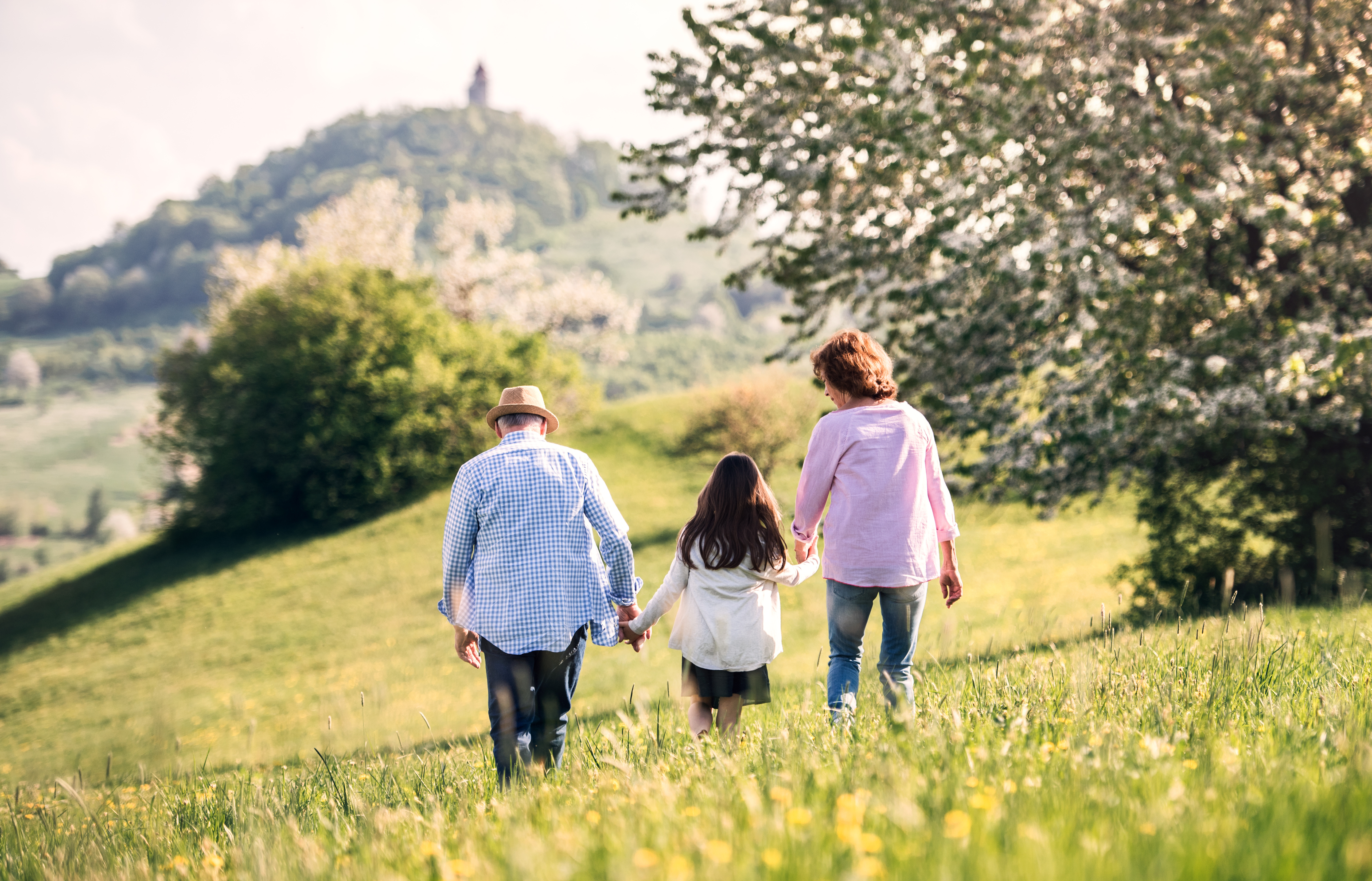 Grandparents walking with granddaughter in nature