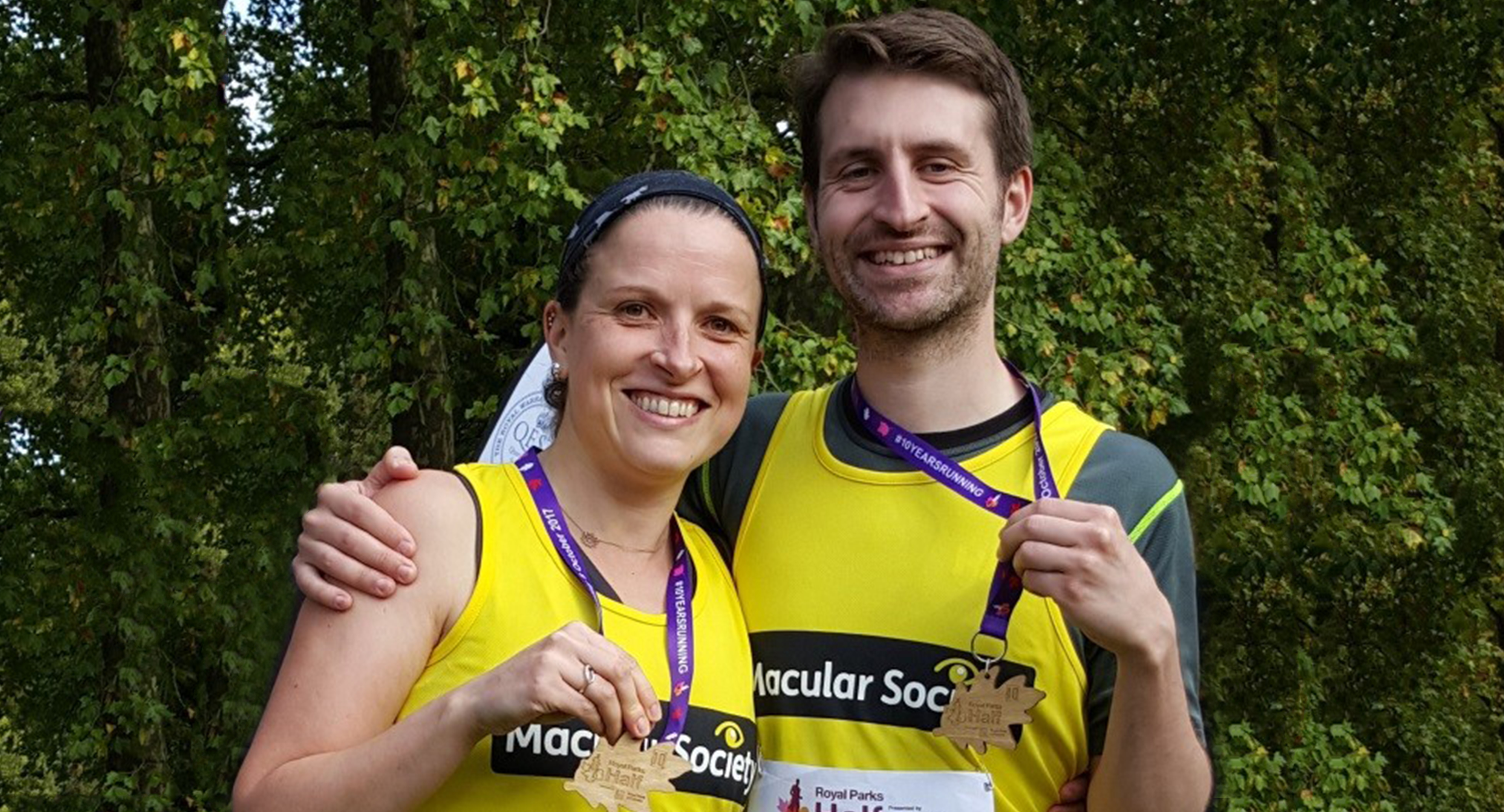 Two runners with vests and medals