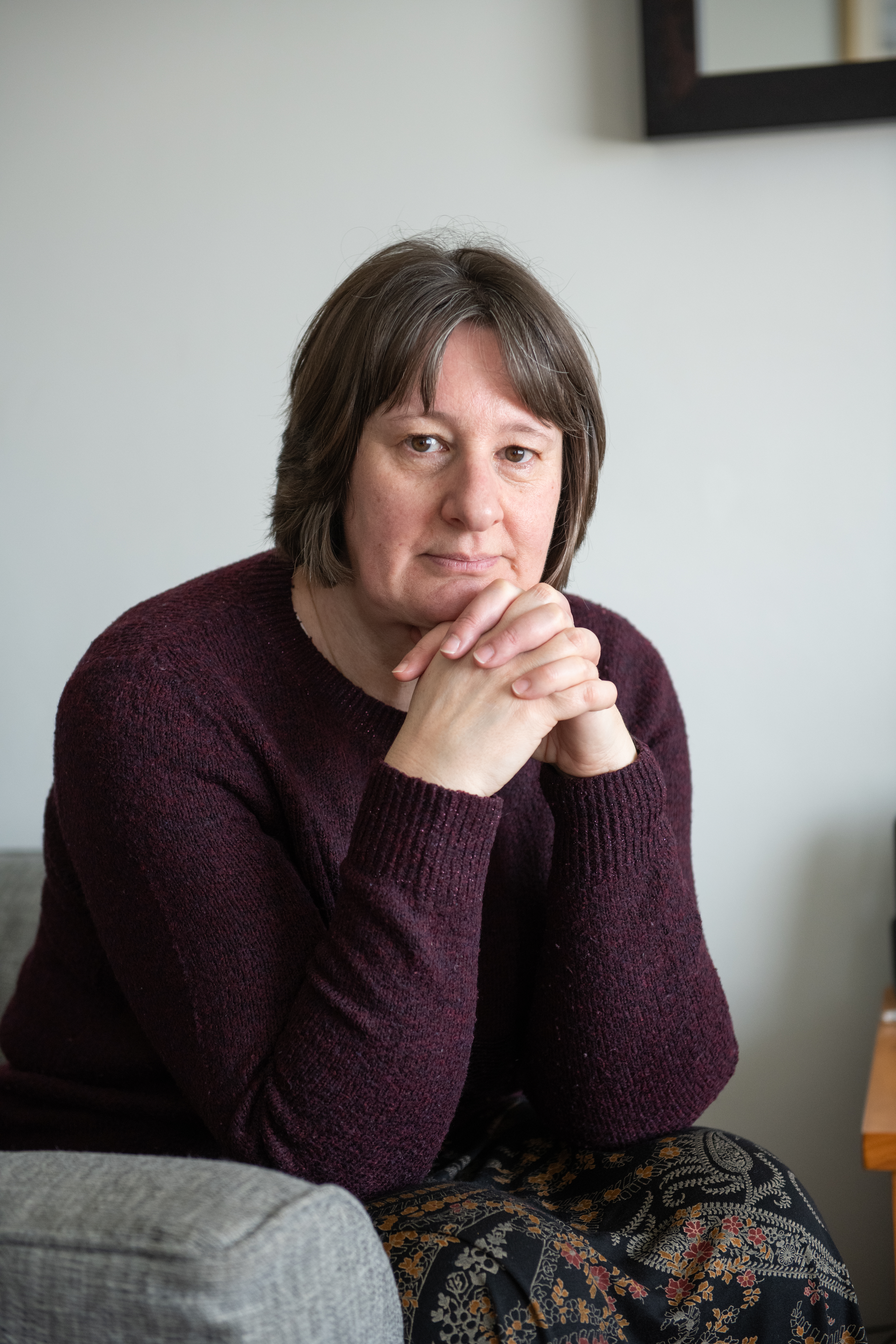 Nancy looking into the camera with her hands held near her face